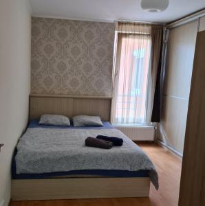 a bedroom with a bed with a blanket and a window at Aphrodité apartman in Budapest
