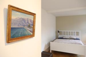 a bedroom with a bed and a painting on the wall at City Center Apartment in Interlaken