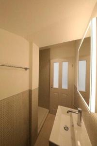 a bathroom with a sink and a mirror and a shower at City Center Apartment in Interlaken