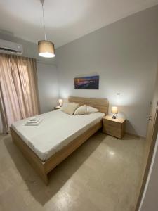 1 dormitorio con 1 cama grande y 2 mesitas de noche en Christy's House Anavissos / Ανάβυσσος, en Anavyssos