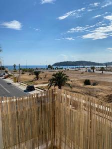 una recinzione in legno con una spiaggia sullo sfondo di Christy's House Anavissos / Ανάβυσσος ad Anávissos