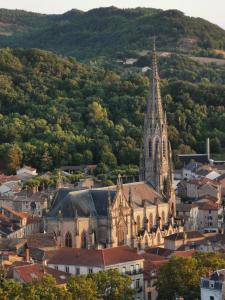 an old church with a steeple in a city at Appartement dans maison individuelle LE CAYLUS BAS in Saint-Affrique