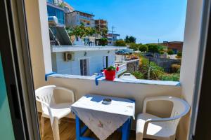 a small table and chairs on a balcony with a view at Joyous Apartments in Sarandë