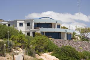 a white house on top of a rocky hill at Cliff House Beachfront Villas in Moonta