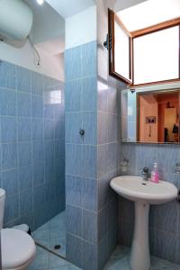 a bathroom with a sink and a toilet and a mirror at Joyous Apartments in Sarandë