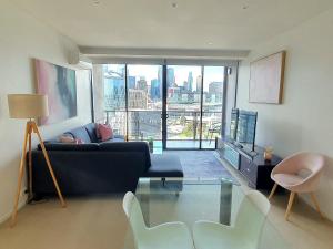 sala de estar con sofá azul y mesa de cristal en Harbour Escape Apartments Docklands en Melbourne