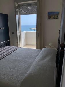 a bedroom with a bed and a view of the ocean at Hotel Peschici in Peschici