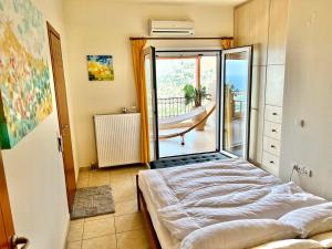 a bedroom with a bed and a balcony with a tub at Villa Oleander in Elounda