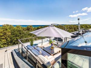 een buitenterras met stoelen en een parasol bij FeWo Prora - Stella Maris Dachterrasse in Binz