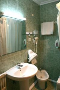 a bathroom with a sink and a toilet at Hotel Cervantes in Alicante