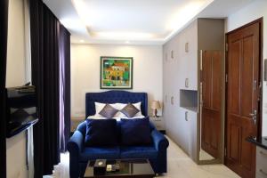 a bedroom with a blue chair and a bed at Aisha HOTELS and APARTMENTS in Hanoi