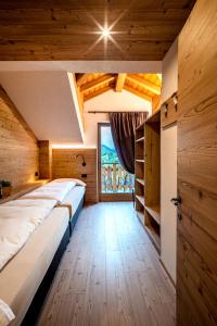 a room with three beds in a room with wooden ceilings at Pradella Apartments in Valdidentro