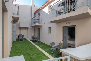 a courtyard in a building with green grass at OLYMPIA ROOMS in Myrina