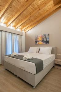 a bedroom with a large bed with two towels on it at OLYMPIA ROOMS in Myrina