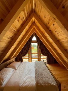 a bed in a wooden attic with a roof at Mountain Villas Žabljak in Žabljak