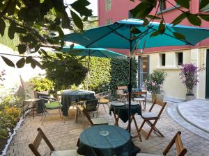 a patio with tables and chairs and an umbrella at Hôtel Saint Clair in Lourdes