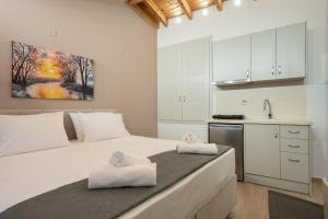 een slaapkamer met een groot wit bed en handdoeken bij OLYMPIA ROOMS in Mirina
