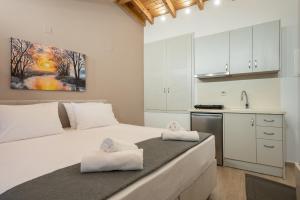 a bedroom with a large white bed with towels on it at OLYMPIA ROOMS in Myrina