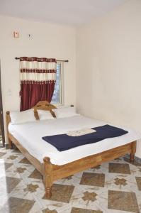 ein großes Bett in einem Zimmer mit Fenster in der Unterkunft Sanjay Homestay New Hampi in Hampi