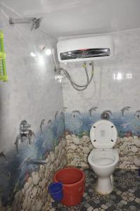 ein Bad mit einem WC und einem Wandgemälde in der Unterkunft Sanjay Homestay New Hampi in Hampi