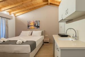 a bedroom with a bed and a sink at OLYMPIA ROOMS in Myrina