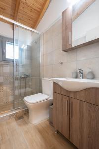 a bathroom with a toilet and a sink and a shower at OLYMPIA ROOMS in Myrina