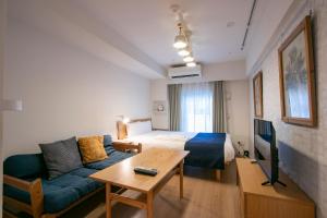 una camera d'albergo con letto, divano e tavolo di KARIO SASAZUKA TERRACE a Tokyo