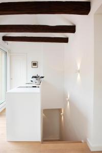 a white kitchen with a white counter and wooden ceilings at Quartier 99 in Innsbruck