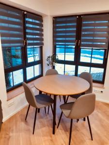 a dining room with a table and chairs and windows at City Park Loft in Münchberg