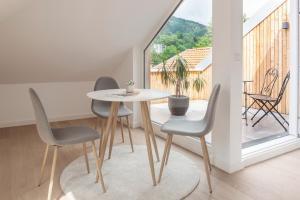 einen Tisch und Stühle in einem Zimmer mit Balkon in der Unterkunft Quartier 99 in Innsbruck