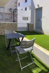 two chairs and a picnic table in a yard at OLYMPIA ROOMS in Myrina