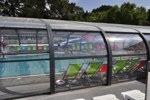 a swimming pool with green chairs next to a swimming pool at Mobilhome Victory 56 in Quiberon