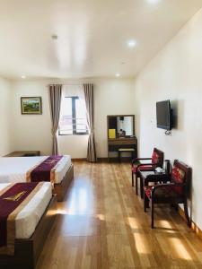 a hotel room with two beds and a television at Kim Ngan Ha Long Hotel in Ha Long