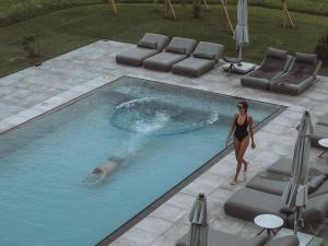 a woman in a bathing suit standing in a swimming pool at Purest in Achenkirch