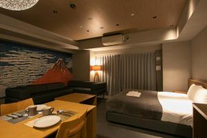 a hotel room with a bed and a table and a couch at Minn Ueno in Tokyo