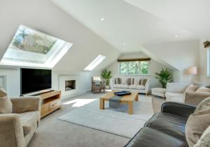 a living room with a couch and a tv and a table at La Villa in Rottingdean