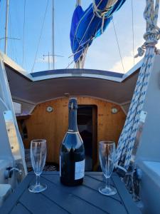 Una botella de vino y dos copas en una mesa en un barco. en VOILIER AU SOLEIL LEVANT, en Le Havre