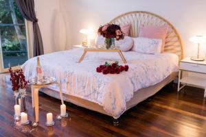 a bedroom with a bed with a table with flowers on it at Shambala Eco Retreat in Mount Tamborine