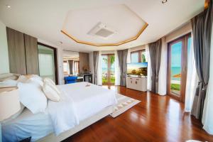ein Schlafzimmer mit einem weißen Bett und einem Fernseher in der Unterkunft Yotaka Khanom in Khanom
