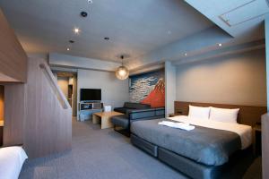 um quarto de hotel com uma cama e um sofá em Minn Ueno em Tóquio