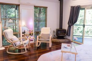 a living room with chairs and a wood stove at Shambala Eco Retreat in Mount Tamborine