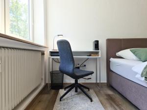 ein Schlafzimmer mit einem Schreibtisch und einem Stuhl neben einem Bett in der Unterkunft Schöne Ferienwohnung im Zentrum mit Self Check-In und Free Wifi in Essen