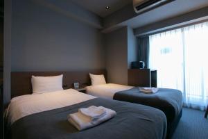 um quarto de hotel com duas camas e uma janela em Minn Ueno em Tóquio