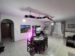 a living room with a table and chairs and purple lights at Elli's House in Keramoti