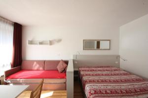 - une chambre avec un lit et un canapé dans l'établissement Appartamenti Roulette Montana Marilleva 900, à Mezzana