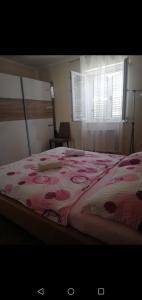 a bedroom with a bed with a pink blanket and a window at Apartment Sunset in Šibenik