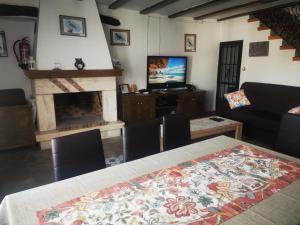 uma sala de estar com uma mesa e uma lareira em La Casa de los Pájaros em Vélez Blanco