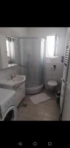 uma casa de banho com um chuveiro, um lavatório e um WC. em Apartment Sunset em Sibenik