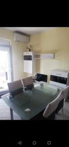 uma cozinha com uma mesa de vidro e 2 cadeiras em Apartment Sunset em Sibenik