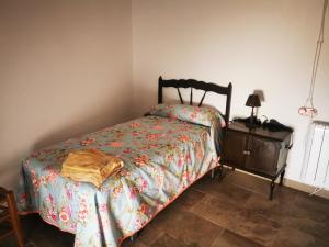 um quarto com uma cama e uma mesa com um candeeiro em La Casa de los Pájaros em Vélez Blanco